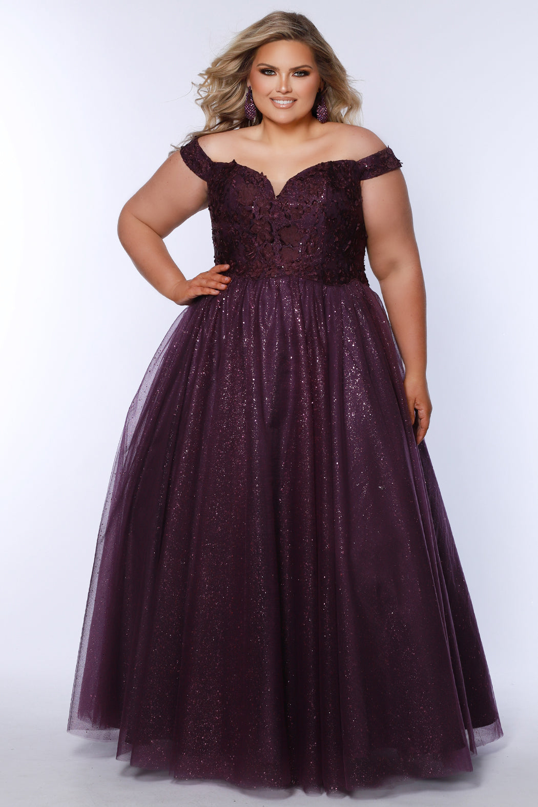 Plus size elegeant off-the-shoulder ball gown with 3D floral lace and sparkle tulle. Full A-line skirt and center back zipper. Availablie in burgundy red, onyx black and plum purple in plus sizes 14-40. Style SC7428 from Sydney's Closet.