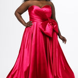 Sydney's Closet style SC7437 in pink. 

Plus size A-line formal dress with strapless, pleated bodice, natural waistline with detachable oversized bow, A-line skirt with horsehair hem in silky satin fabric.