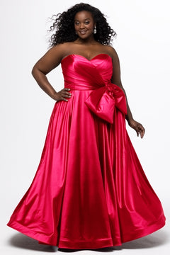 Sydney's Closet style SC7437 in pink. 

Plus size A-line formal dress with strapless, pleated bodice, natural waistline with detachable oversized bow, A-line skirt with horsehair hem in silky satin fabric.