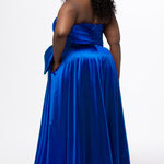 Sydney's Closet style SC7437 in royal blue. 

Plus size A-line formal dress with strapless, pleated bodice, natural waistline with detachable oversized bow, A-line skirt with horsehair hem in silky satin fabric.