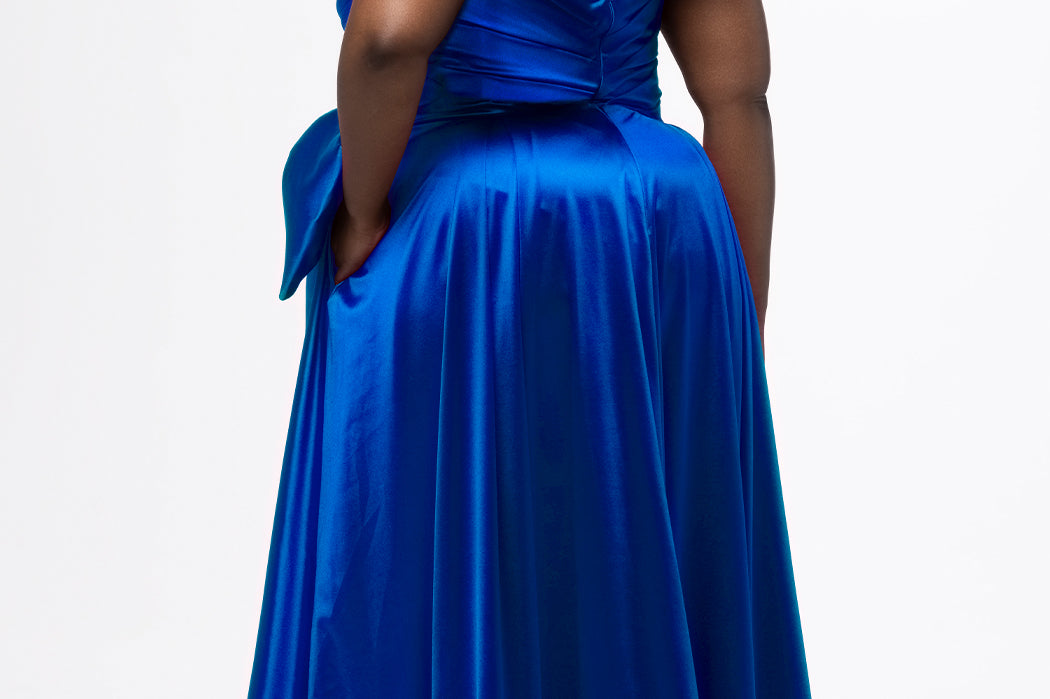 Sydney's Closet style SC7437 in royal blue. 

Plus size A-line formal dress with strapless, pleated bodice, natural waistline with detachable oversized bow, A-line skirt with horsehair hem in silky satin fabric.