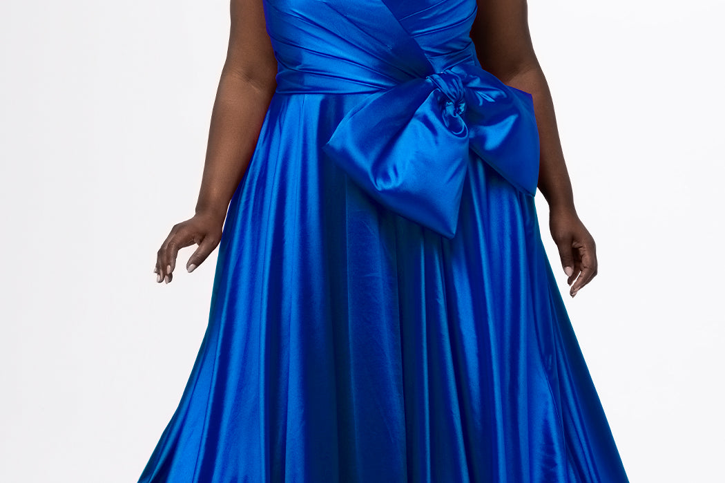 Sydney's Closet style SC7437 in royal blue. 

Plus size A-line formal dress with strapless, pleated bodice, natural waistline with detachable oversized bow, A-line skirt with horsehair hem in silky satin fabric.