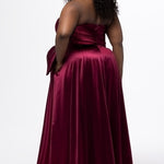 Sydney's Closet style SC7437 in wine. 

Plus size A-line formal dress with strapless, pleated bodice, natural waistline with detachable oversized bow, A-line skirt with horsehair hem in silky satin fabric.