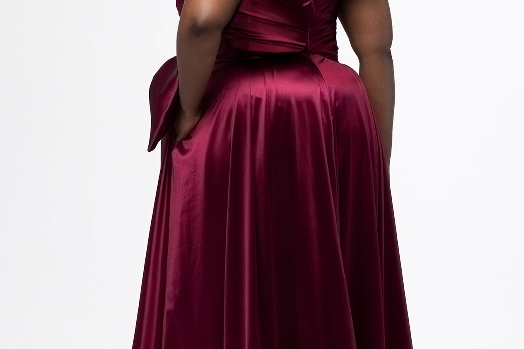 Sydney's Closet style SC7437 in wine. 

Plus size A-line formal dress with strapless, pleated bodice, natural waistline with detachable oversized bow, A-line skirt with horsehair hem in silky satin fabric.