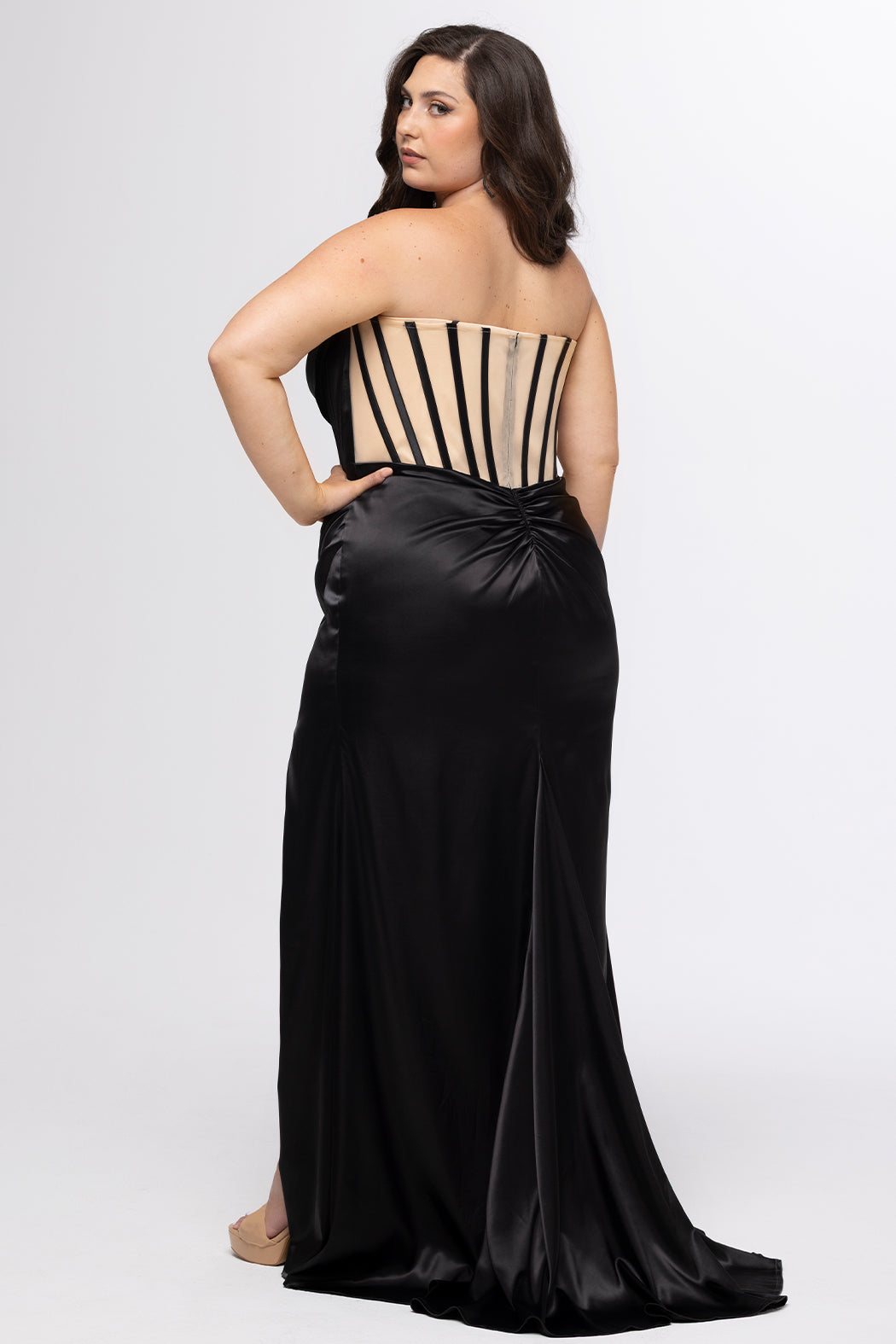 Sydney's Closet style SC7438 in onyx black or onyx black/nude. 

Slim, fitted silhouette with cay eye bodice and hot fix stone detail. Pleated drape over the bust line, exposed corset boning, basque waistline and slim fitted skirt with ruching and slit.  

Choose from tone-on-tone back bodice or color with nude lining on the upper back bodice. 