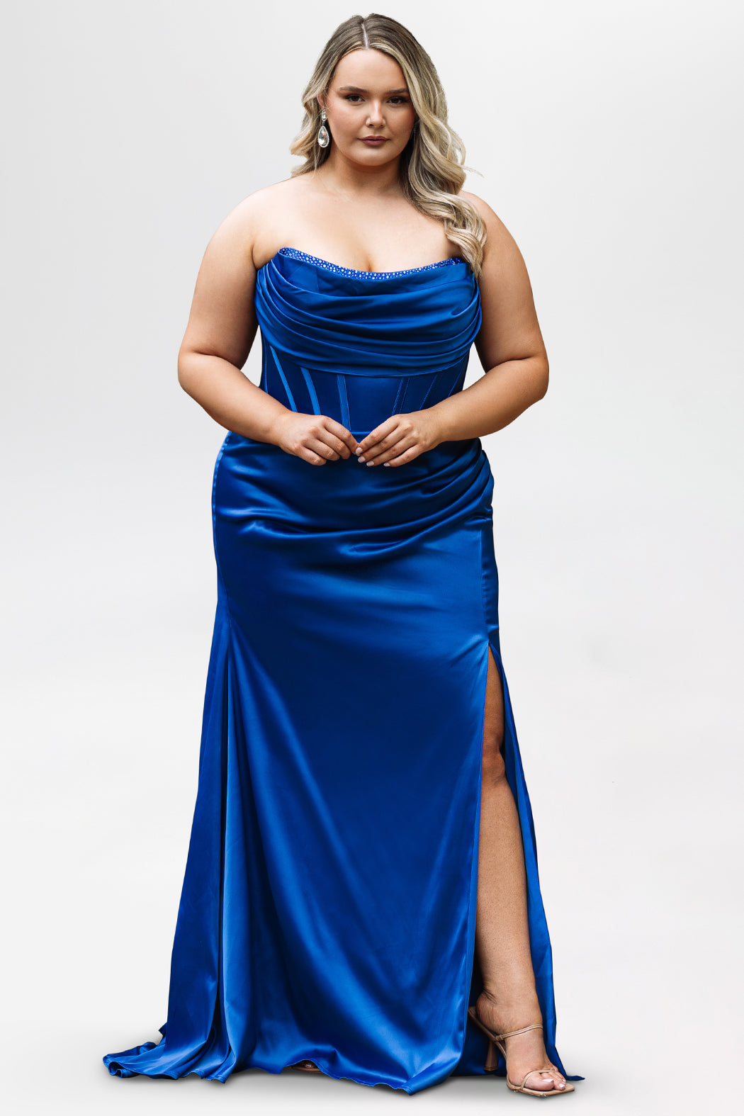 Sydney's Closet style SC7438 in cobalt or cobalt/nude. 

Slim, fitted silhouette with cay eye bodice and hot fix stone detail. Pleated drape over the bust line, exposed corset boning, basque waistline and slim fitted skirt with ruching and slit.  

Choose from tone-on-tone back bodice or color with nude lining on the upper back bodice. 