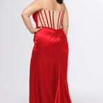 Sydney's Closet style SC7438 in ruby red or ruby red/nude. 

Slim, fitted silhouette with cay eye bodice and hot fix stone detail. Pleated drape over the bust line, exposed corset boning, basque waistline and slim fitted skirt with ruching and slit.  

Choose from tone-on-tone back bodice or color with nude lining on the upper back bodice. 
