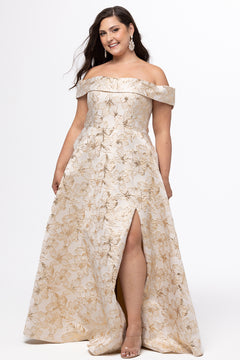 Sydney's Closet SC7440 in gold floral brocade.

Plus size A-line silhouette with off-the-shoulder neckline and fold over cuff on bodice.  Natural waistline with A-line skirt, pockets and left leg slit. 