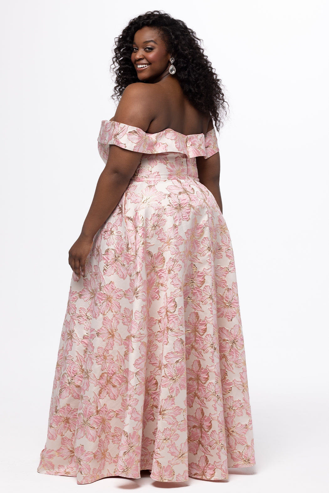 Sydney's Closet SC7440 in light pink floral brocade with gold accents.

Plus size A-line silhouette with off-the-shoulder neckline and fold over cuff on bodice.  Natural waistline with A-line skirt, pockets and left leg slit. 