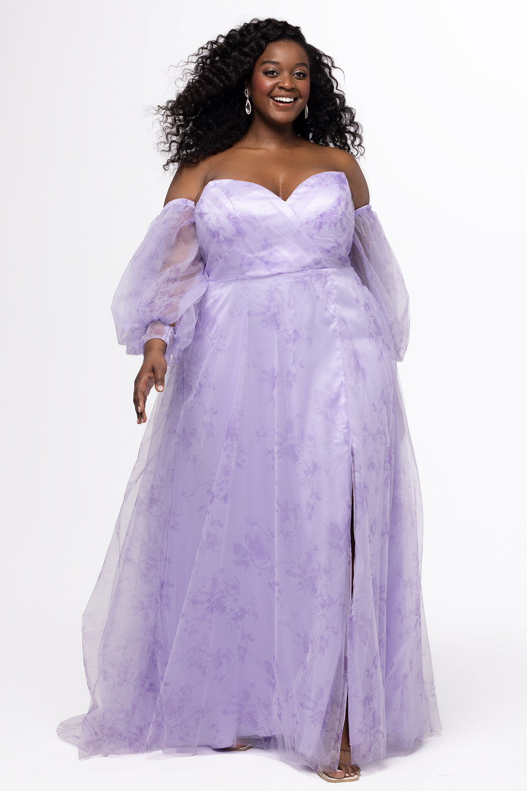 Sydney's Closet style SC7445 in lilac purple floral. 

Plus size A-line strapless formal dress in tulle.  Strapless, pleated, sweetheartneckline, natural waistline, A-line skirt with slit and pockets with detachable puff sleeves.