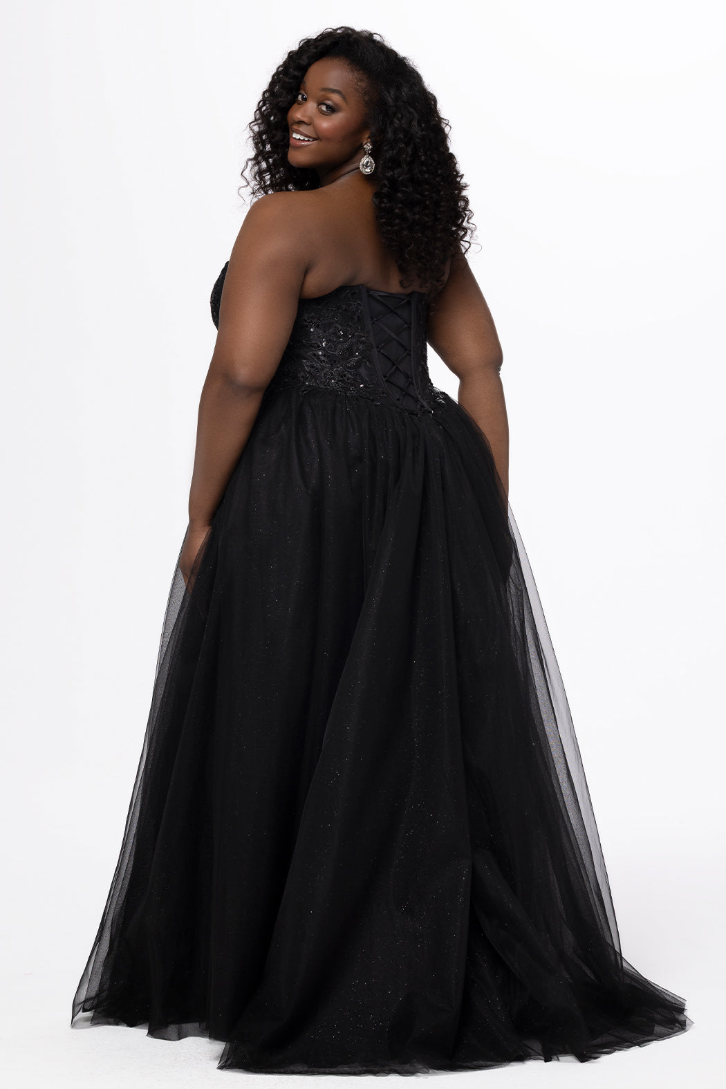 Sydney's Closet style SC7450 in black.

Ball gown silhouette, strapless bodice with deep V-mesh insert covered in lace appliques and exposed corset boning. Basque waistline and full sparkle tulle a-line skirt. Lace up back with modesty panel. 