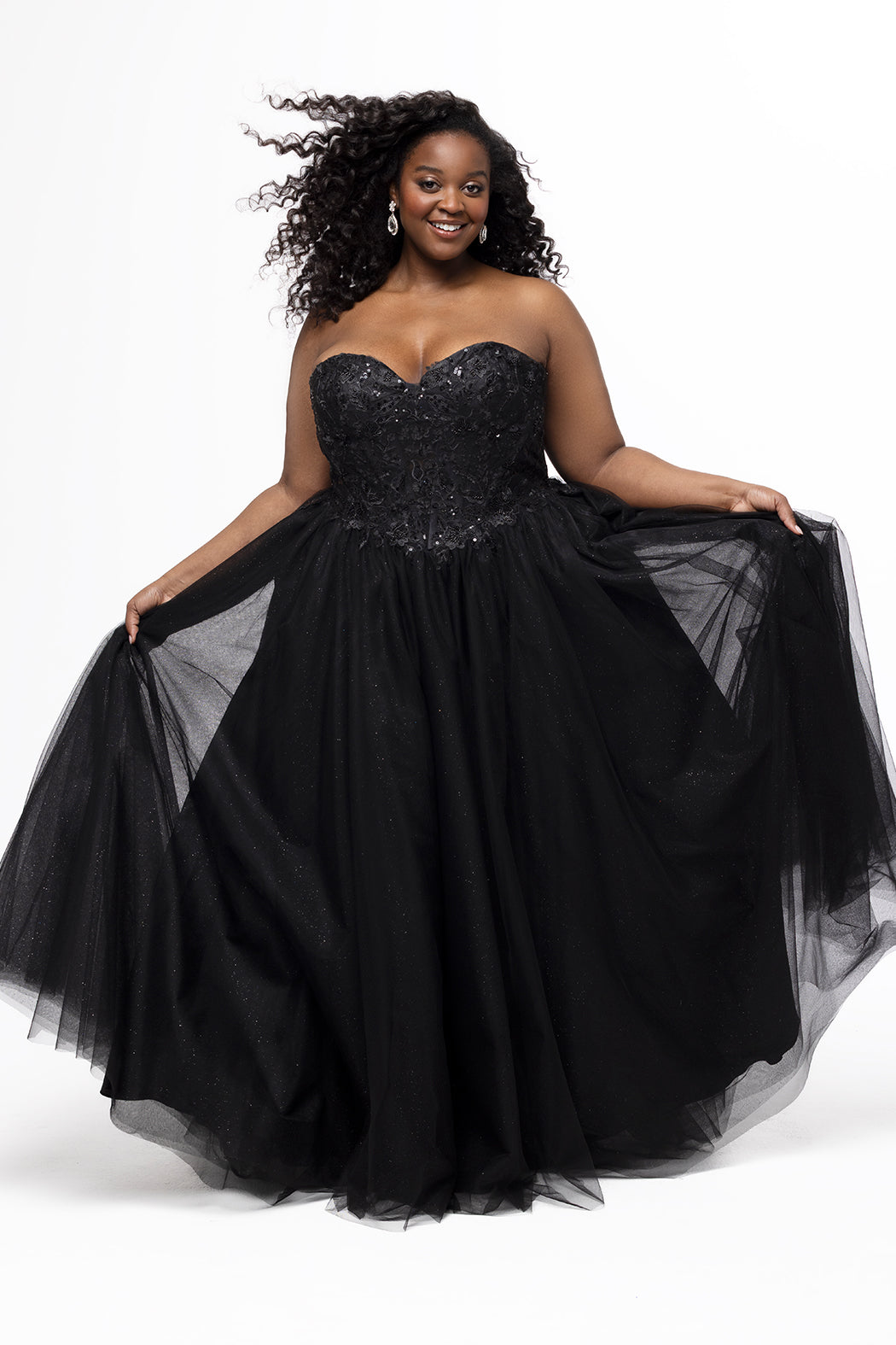Sydney's Closet style SC7450 in black.

Ball gown silhouette, strapless bodice with deep V-mesh insert covered in lace appliques and exposed corset boning. Basque waistline and full sparkle tulle a-line skirt. Lace up back with modesty panel. 