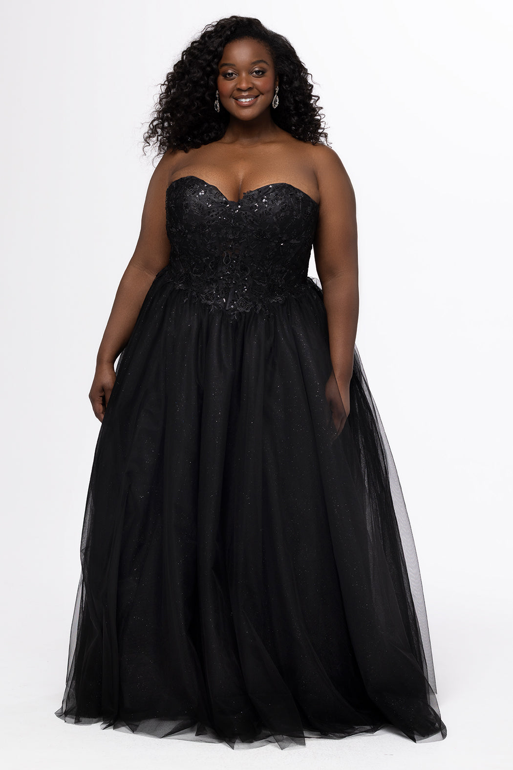Sydney's Closet style SC7450 in black.

Ball gown silhouette, strapless bodice with deep V-mesh insert covered in lace appliques and exposed corset boning. Basque waistline and full sparkle tulle a-line skirt. Lace up back with modesty panel. 