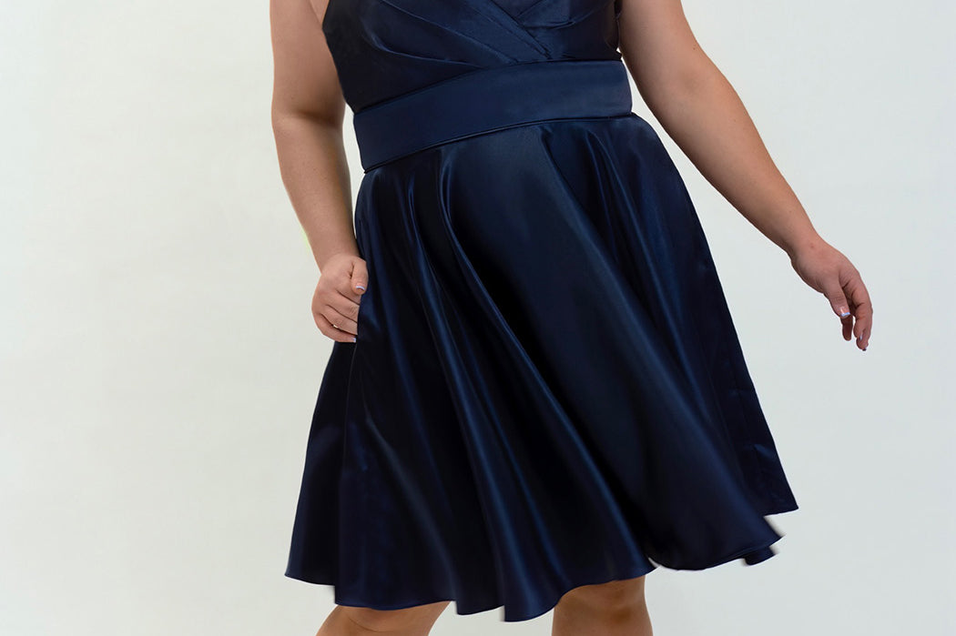 This is SC8124 in our Sydney's Closet Homecoming collection. This plus size party dress comes in black, red, green, and blue! This dress has spaghetti straps, a v neckline, and a beautiful rouched bodice! This a-line satin gown flows beautifully with your dance moves! With the length hitting right at your knees, and pockets, it is the perfect dress for this homecoming season!