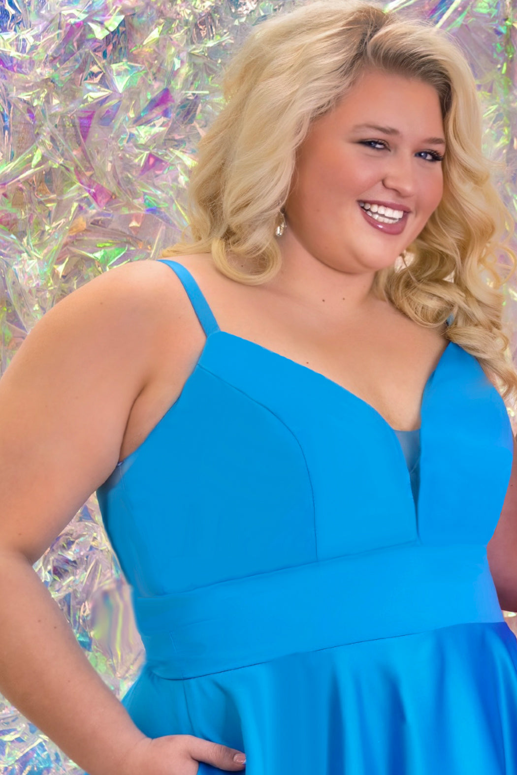 This is SC8126 in our Sydney's Closet Homecoming collection. This plus size party dress comes in blue and coral! This dress has spaghetti straps and a v-neckline with a mesh insert to match the color of the dress! This a-line satin gown flows beautifully with your dance moves! To make this gown perfect, we have added pockets which is why you need it for this homecoming season!