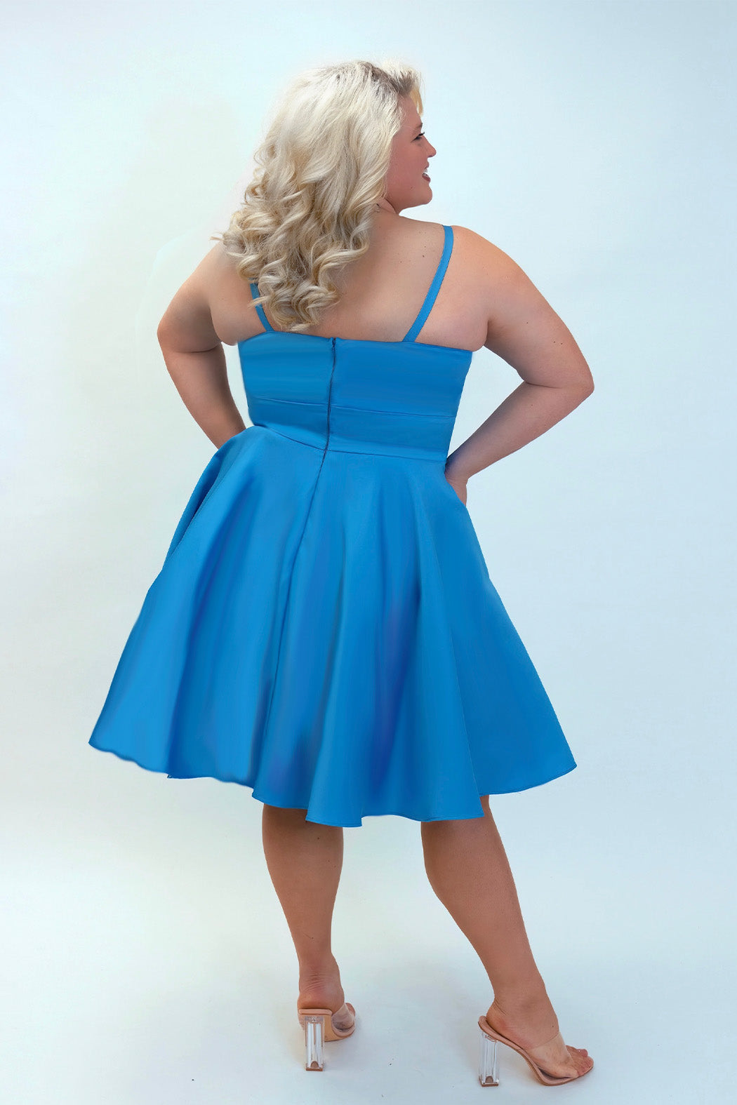 This is SC8126 in our Sydney's Closet Homecoming collection. This plus size party dress comes in blue and coral! This dress has spaghetti straps and a v-neckline with a mesh insert to match the color of the dress! This a-line satin gown flows beautifully with your dance moves! To make this gown perfect, we have added pockets which is why you need it for this homecoming season!