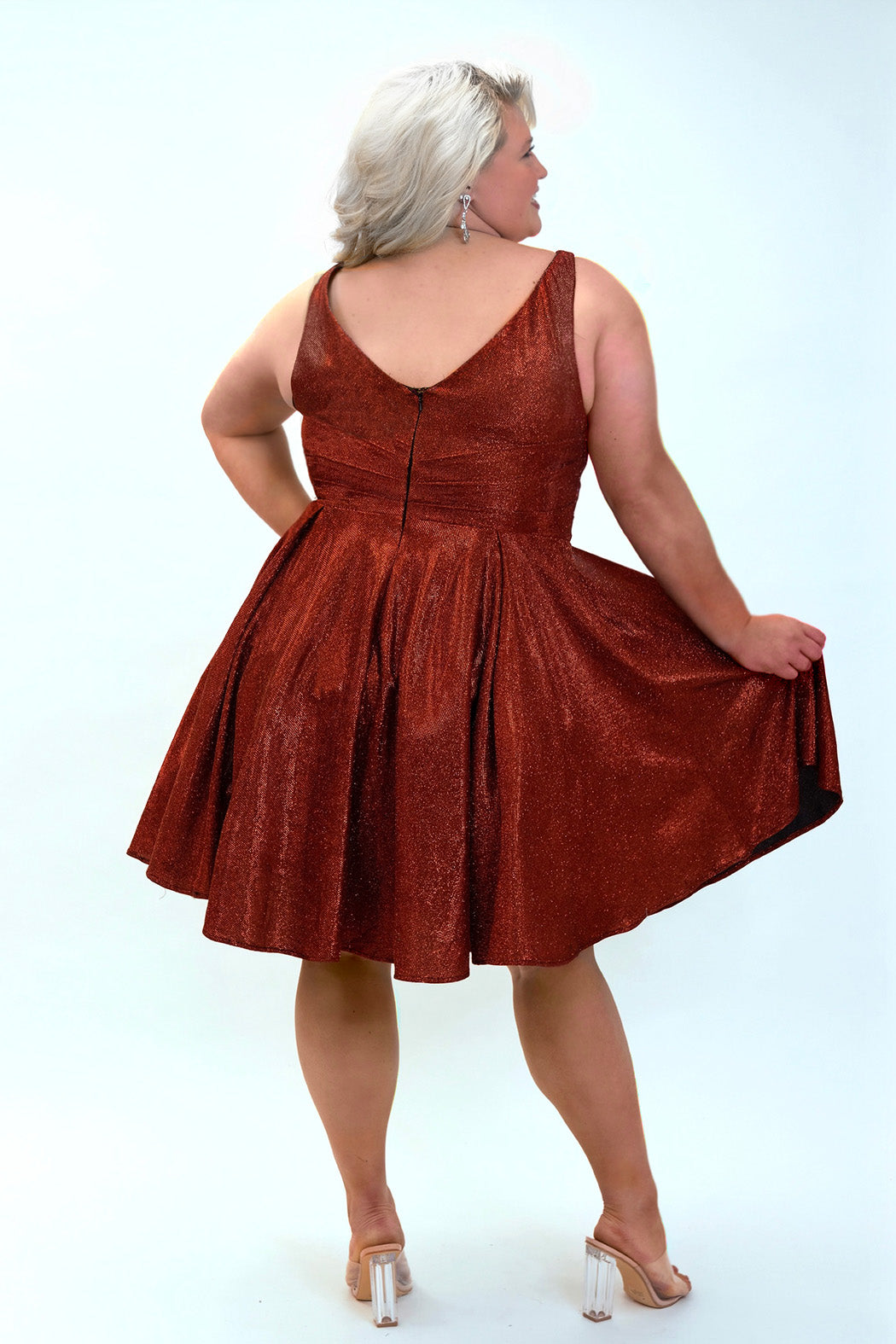 This is SC8132 in our Sydney's Closet Homecoming collection. This plus size party dress comes in black, blue, gold, and red! This dress has bra friendly straps, a v-neckline, and a pleated waistline. This metallic shimmer knit a-line dress has folds to make it flow so beautifully! This gown has pockets which makes it the most perfect for this homecoming season!