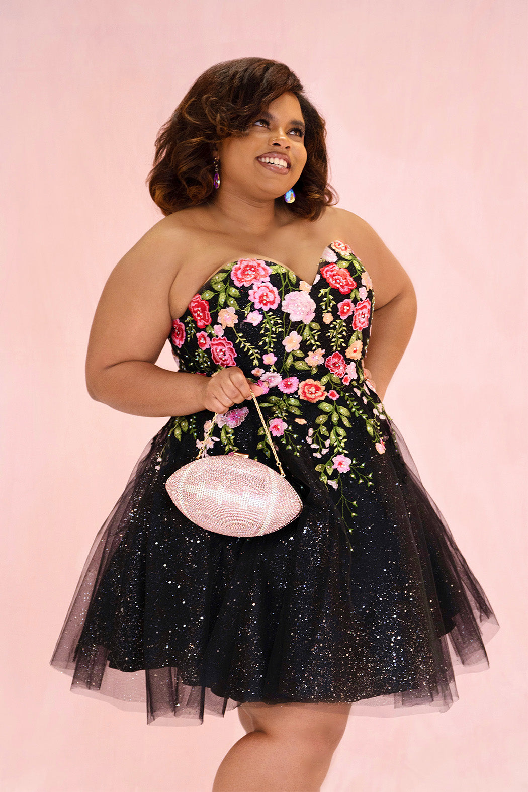 SC8137 Front view. Black sparkle tulle short a-line party dress with pink floral embroidered roses. Strapless sweetheart neckline, long invisible center back zipper.  Available only in black floral. Curvy sizes 10-32. Model in picture is 5 foot 9 inches and a size 16.