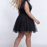 Short A-line plus size flowy party dress SC8153 by Sydney's Closet in the color Onyx black. Back view. Layers of dense sparkle tulle and a satin lining. V-neckline with thick bra-friendly straps and detachable bows at the top of the shoulder. Pleated bodice and 3 inch pleated waistband. Pockets and long invisible center back zipper. Available in Shamrock green, Admiral blue, Firecracker red and Shamrock green in sizes 14-32. Model is 5'9. 