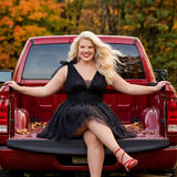 Woman in a black dress sitting on the back of a red pickup truck with autumn foliage in the background

Short A-line plus size flowy party dress SC8153 by Sydney's Closet in the color Onyx black. Front view. Layers of dense sparkle tulle and a satin lining. V-neckline with thick bra-friendly straps and detachable bows at the top of the shoulder. Pleated bodice and 3 inch pleated waistband. Pockets and long invisible center back zipper. Available in Shamrock green, Admiral blue, Firecracker red and Shamrock 