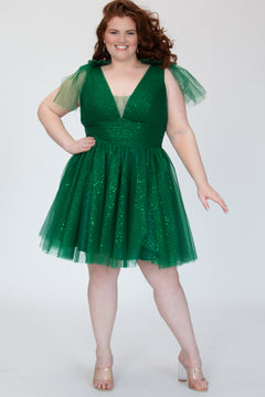 Short A-line plus size flowy party dress SC8153 by Sydney's Closet in the color Shamrock green. Front view. Layers of dense sparkle tulle and a satin lining. V-neckline with thick bra-friendly straps and detachable bows at the top of the shoulder. Pleated bodice and 3 inch pleated waistband. Pockets and long invisible center back zipper. Available in Shamrock green, Admiral blue, Firecracker red and Onyx black in sizes 14-32. Model is 5'9. 