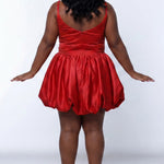 Plus-size model wearing a red sleeveless mini dress with a scoop back, rhinestone & pearl embellished fitted bodice, and a voluminous bubble hem skirt and center back zipper. She is styled with long wavy black hair, dangling crystal earrings, and nude platform ankle-strap heels, posing against a light gray studio background while.

Sydney's Closet SC8171 in red