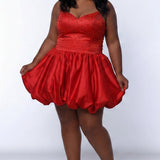 Plus-size model wearing a red sleeveless mini dress with a V-neckline, rhinestone & pearl embellished fitted bodice, and a voluminous bubble hem skirt. She is styled with long wavy black hair, dangling crystal earrings, and nude platform ankle-strap heels, posing against a light gray studio background while holding the sides of the skirt.

Sydney's Closet SC8171 in red