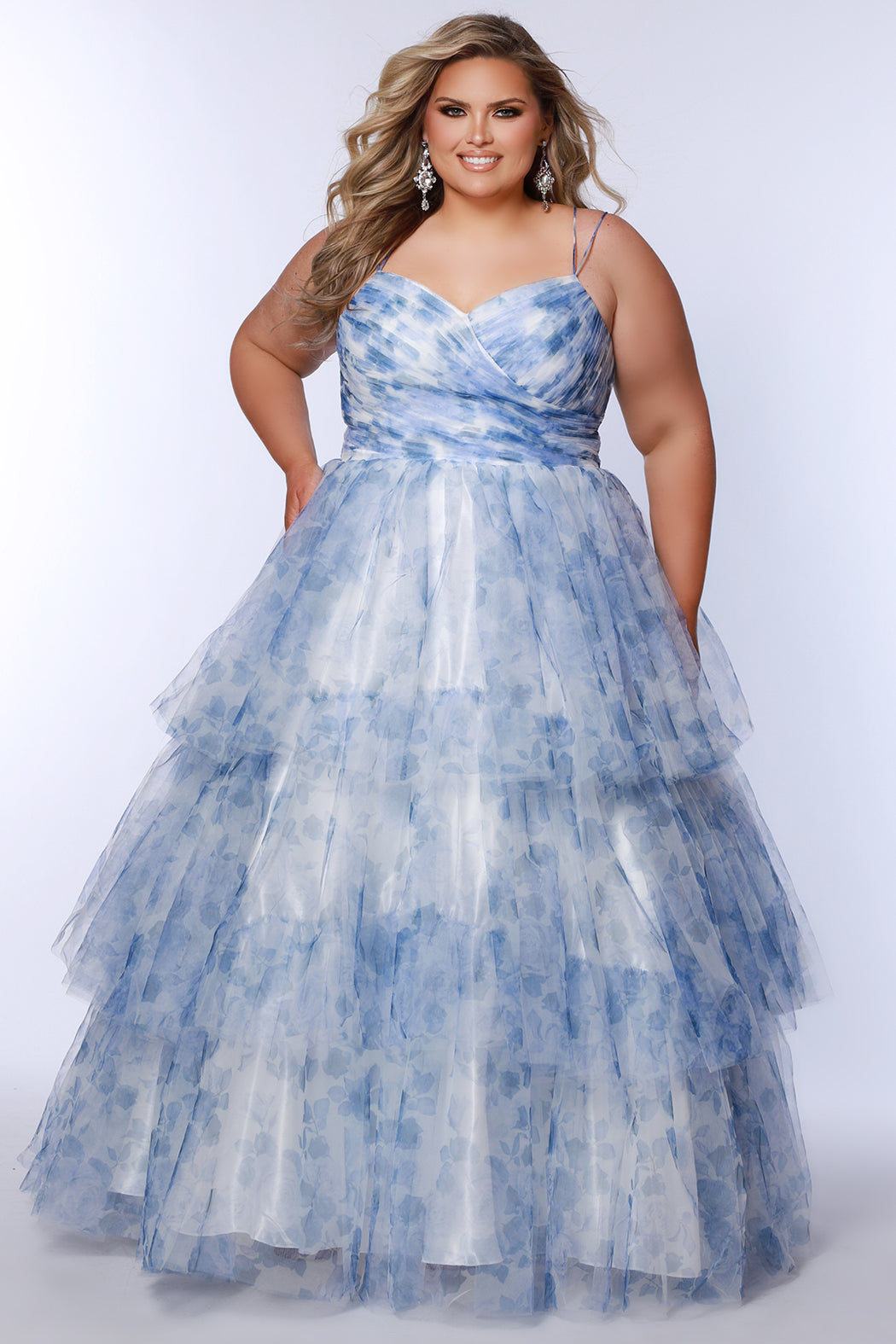 Best selling plus size floral tiered ballgown dress style TE2525 by Tease Prom.  Double spaghetti straps on pleated V-neckline bodice with tiered ball gown skirt in floral print tulle. Available in black floral or blue floral in sizes 14-32.