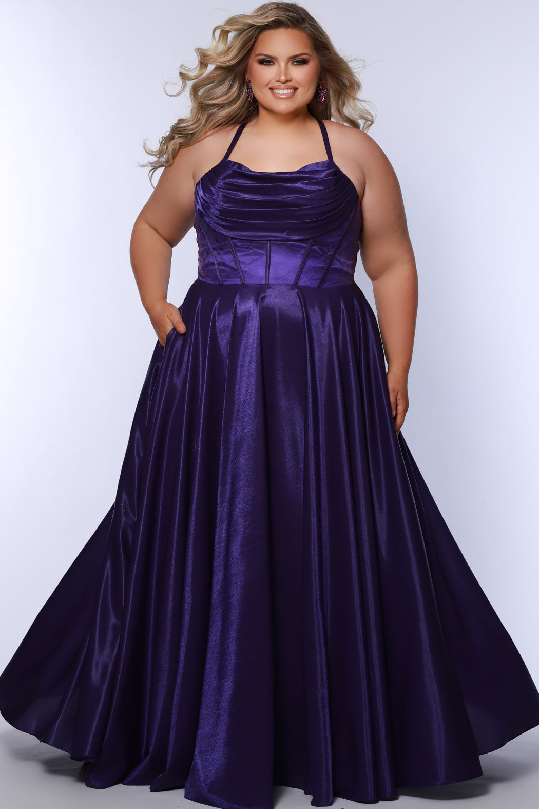 Tease Prom style TE2532 is available in black, blue, pink, purple or red in plus sizes 14-32.  Pleated draped bodice with exposed boning and optional bodice lining. Full A-line skirt with pockets. Straps go into lace up ties with modesty panel on the back. 