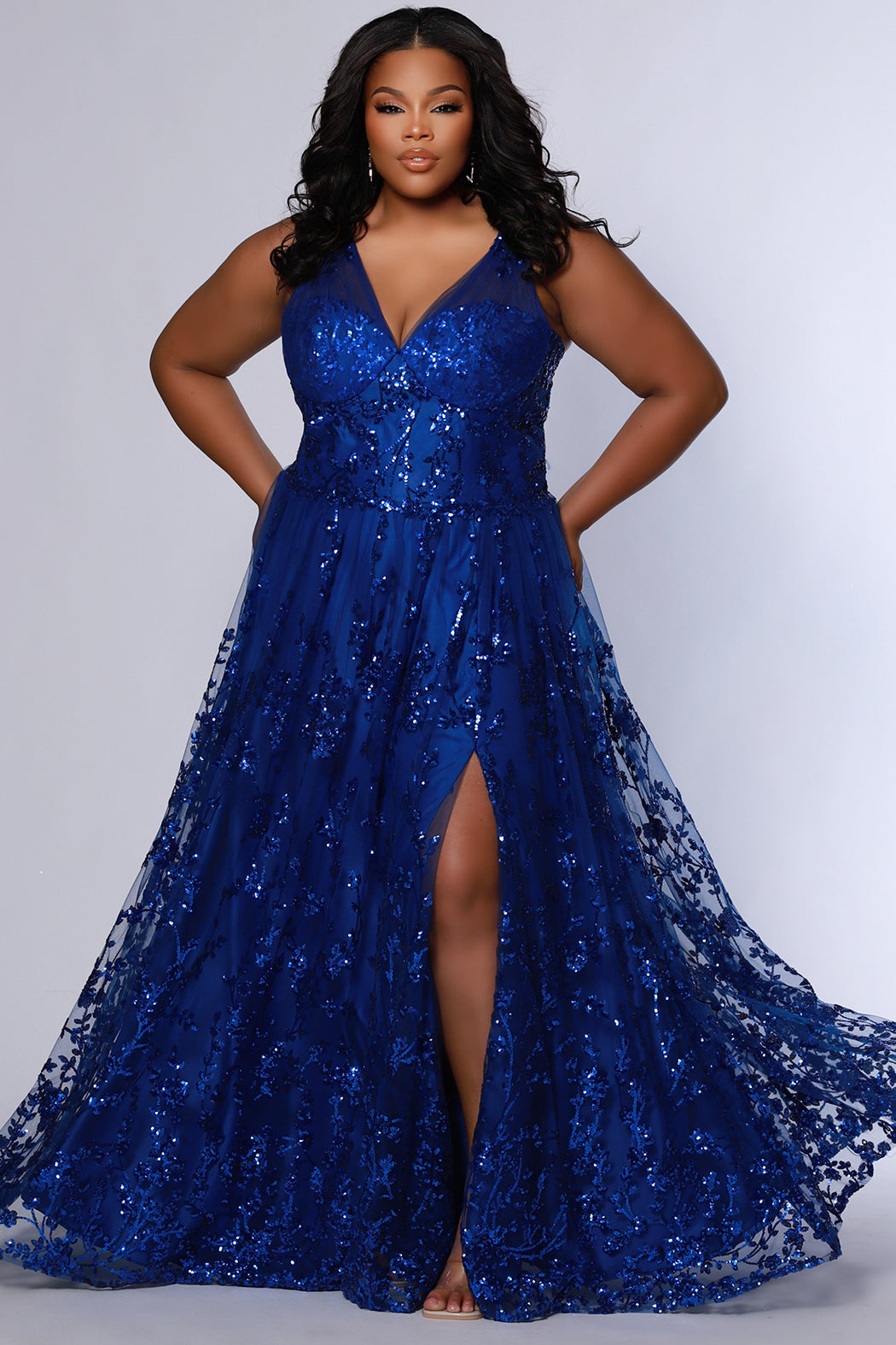 Plus size prom dress style TE2537 by Tease Prom available in Sapphire blue or Orchid purple.  Pleated illusion straps cover a sweetheart bodice with exposed corset boning. Full A-line skirt with slit and glitter sequin appliques on tulle mesh.