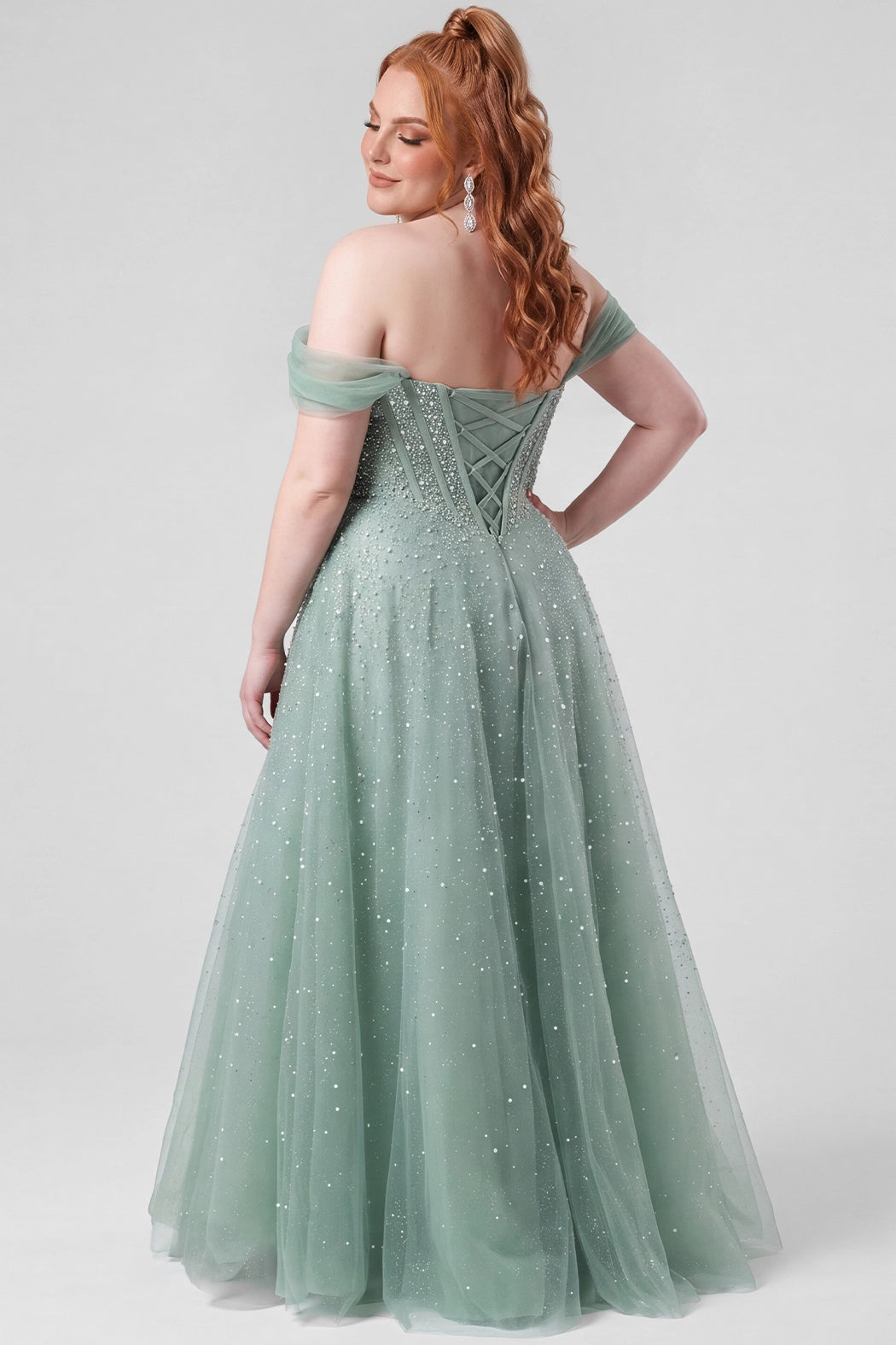 Teen wearing an A-line tulle prom gown with pearl and hot fix beaded details on a white background.

TE2604 in sage green by Tease Prom, exclusively plus size prom dresses designed by Sydney's Closet.