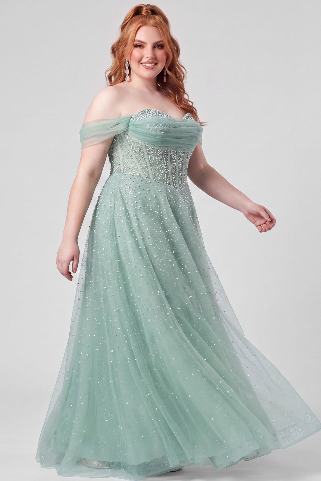 Teen wearing an A-line tulle prom gown with pearl and hot fix beaded details on a white background.

TE2604 in sage green by Tease Prom, exclusively plus size prom dresses designed by Sydney's Closet.