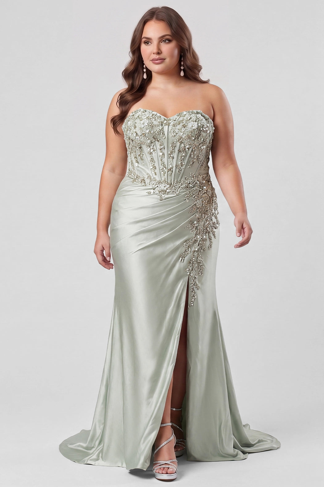 Tease Prom style TE2608 in Sage Green.

Strapless sweetheart plus size fitted gown. Exposed boning with 3D floral appliques and sequin detail on stretch satin. Basque waist, ruched skirt and left leg slit. Lace up back with half zipper, sweep train. Available in sizes 14-28 in Capri Blue, Sage Green and Orchid Purple. 