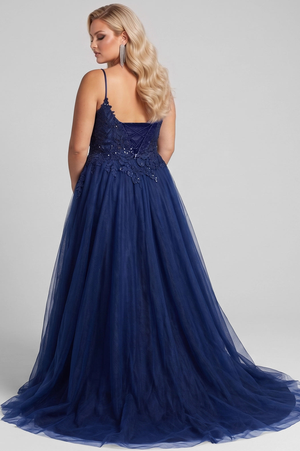 Teen modeling tulle and lace evening gown with a deep V-neckline and slit on a white background.

TE2616 in navy blue by Tease Prom, exclusively plus size prom dresses designed by Sydney's Closet.