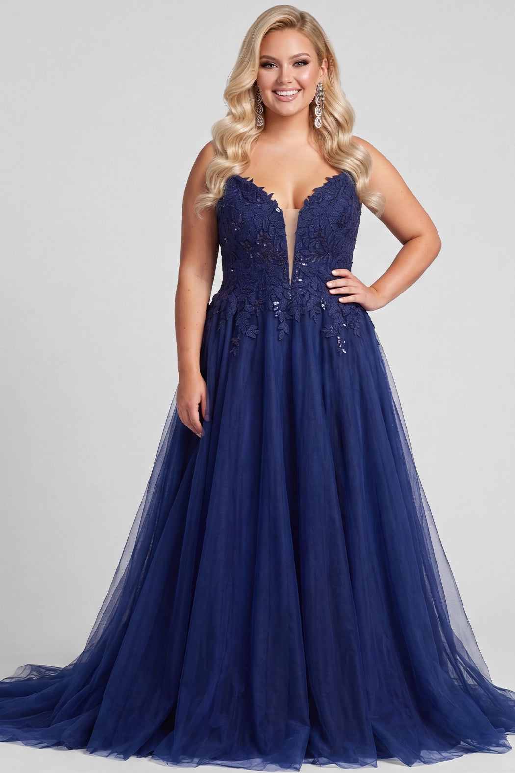 Teen modeling tulle and lace evening gown with a deep V-neckline and slit on a white background.

TE2616 in navy blue by Tease Prom, exclusively plus size prom dresses designed by Sydney's Closet.