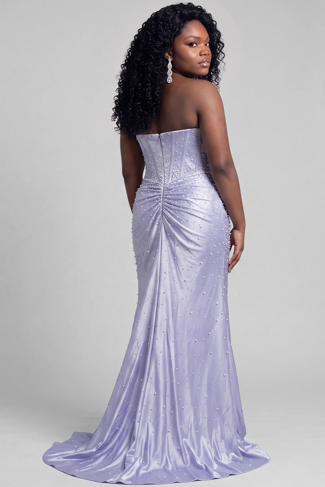 A teen modeling a strapless periwinkle formal gown with a sweetheart neckline, corseted bodice, draped skirt, and thigh-high slit, pearl and hot fix stone details photographed against a light gray studio background.

TE2701 in periwinkleby Tease Prom, exclusively plus size prom dresses designed by Sydney's Closet