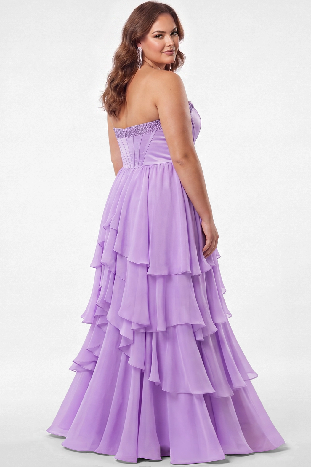 A brunette teen modeling a strapless lilac purple formal gown with a beaded sweetheart neckline, exposed corset boning, basque waistline and a full tiered ruffle skirt, photographed against a light gray studio background.

TE2709 in lilac by Tease Prom, exclusively plus size prom dresses designed by Sydney's Closet.