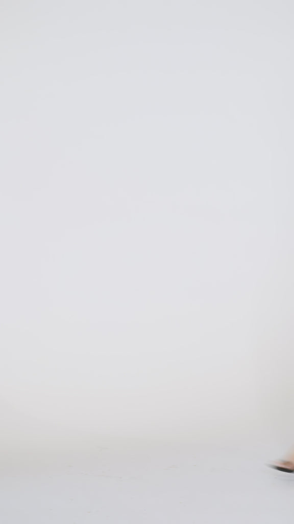 Woman models a black sleeveless sequin mini dress with a V-neckline, turning to show the back before walking off screen.