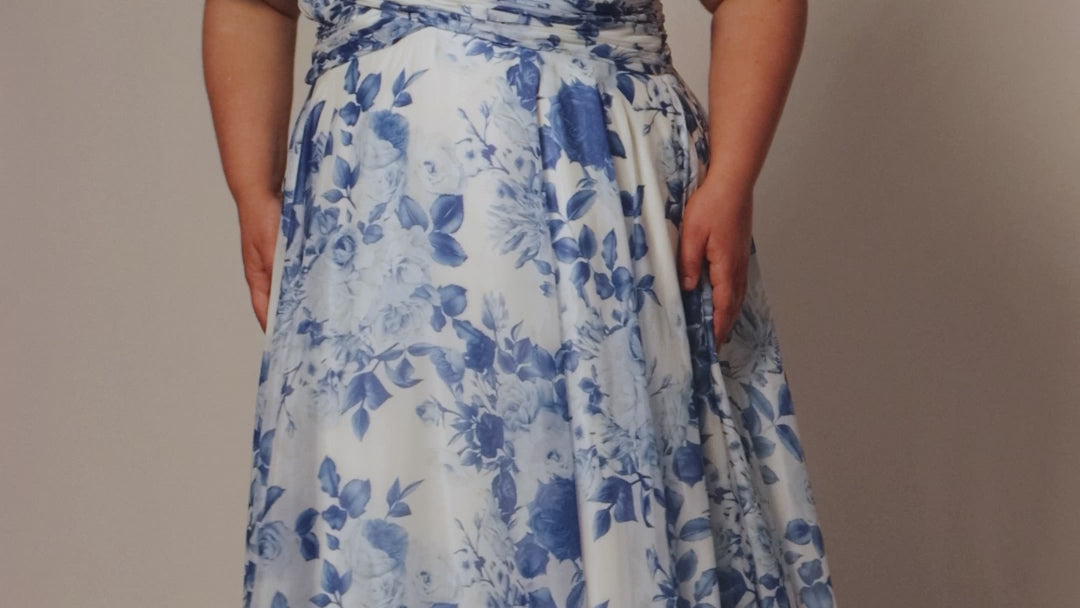 Plus size picnic dress in blue and white floral chiffon print. Criss-cross pleated bodice with spaghetti straps and drape sleeve. A-line skirt and center back zipper. Style SC7421 by Sydney's Closet. 