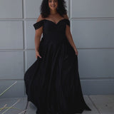 Long formal satin ballgown style SC7400 by Sydney's Closet. Available in sizes 14-32 in colors cobalt blue, onyx black and ruby red.  Pleated bodice with exposed boning, detachable pleated drape sleeves, basque waist and pockets.  