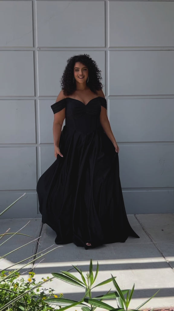 Long formal satin ballgown style SC7400 by Sydney's Closet. Available in sizes 14-32 in colors cobalt blue, onyx black and ruby red.  Pleated bodice with exposed boning, detachable pleated drape sleeves, basque waist and pockets.  