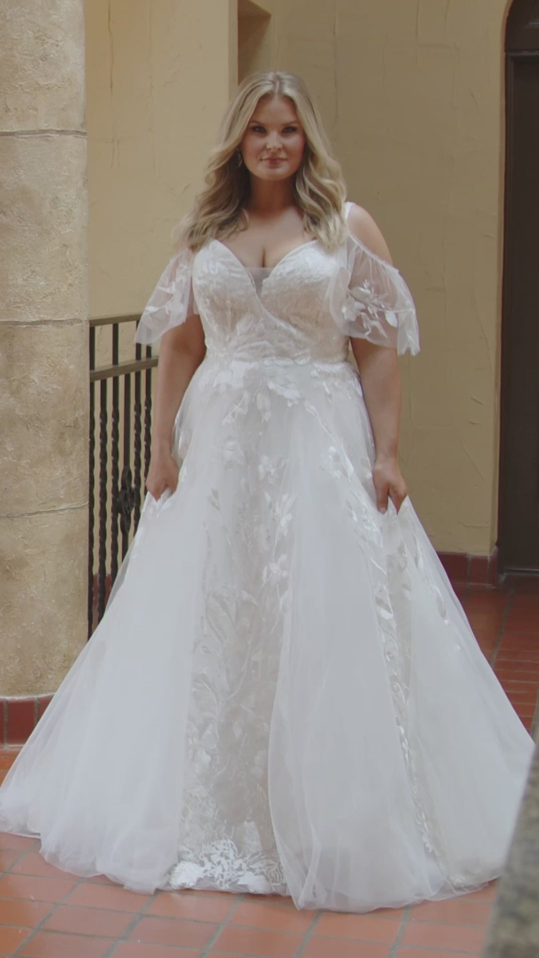 Michelle Bridal MB2408 Ivory. Bridal tulle and satin with leaf and floral appliques, Ballgown silhouette, V-neckline, Spaghetti straps covered in appliques, Drape sleeve, Invisible center back zipper with 24 covered buttons and elastic loops, Natural waistline, Scoop back