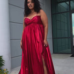 Empire plus size formal dress with spaghetti straps, pleated bodice with knot detail, pockets and slit. Available in gold, onyx black and ruby red. SC7414 by Sydney's Closet