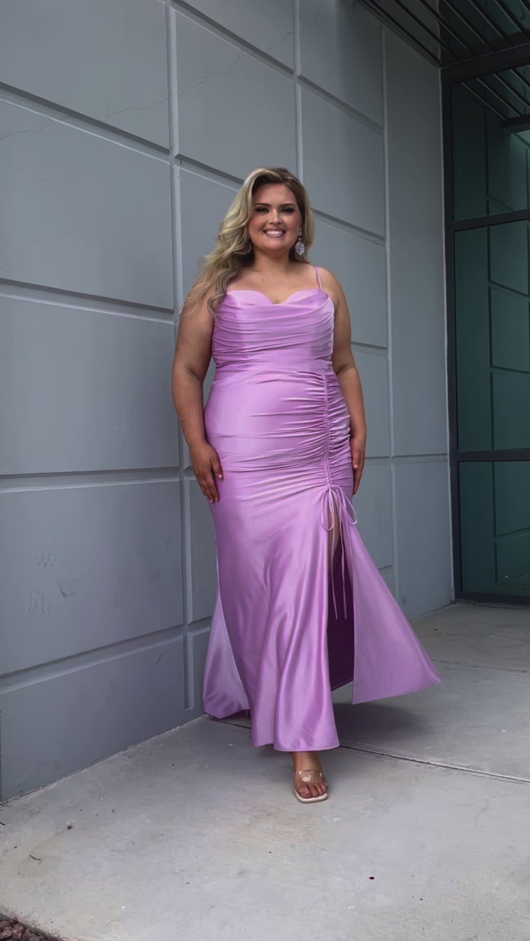 Slim fitted stretch satin plus size formal prom dress.  Pleated bodice, ruched skirt with gathered ties on slit, spaghetti straps and ruched back skirt with train.  Availablie in light blue, orange and lilac in sizes 14-24. Style SC7422 by Sydney's Closet. 