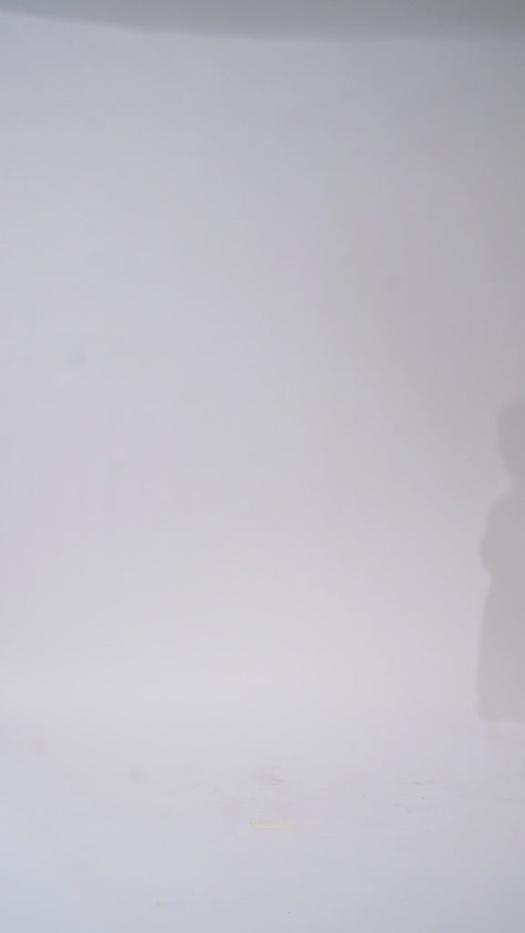 Woman models a white strapless lace tea length dress with a sweetheart neckline and corset bodice, turning to show the back before walking off screen.