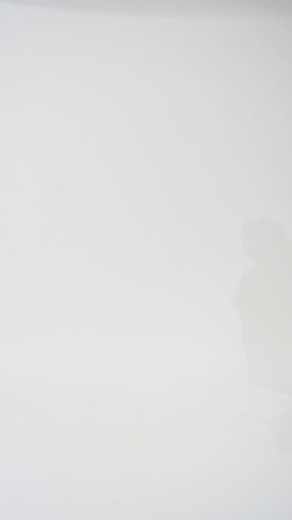 Woman models a black sequin A-line dress with a V-neckline and flowing cape sleeves, turning to show the back before walking off screen.