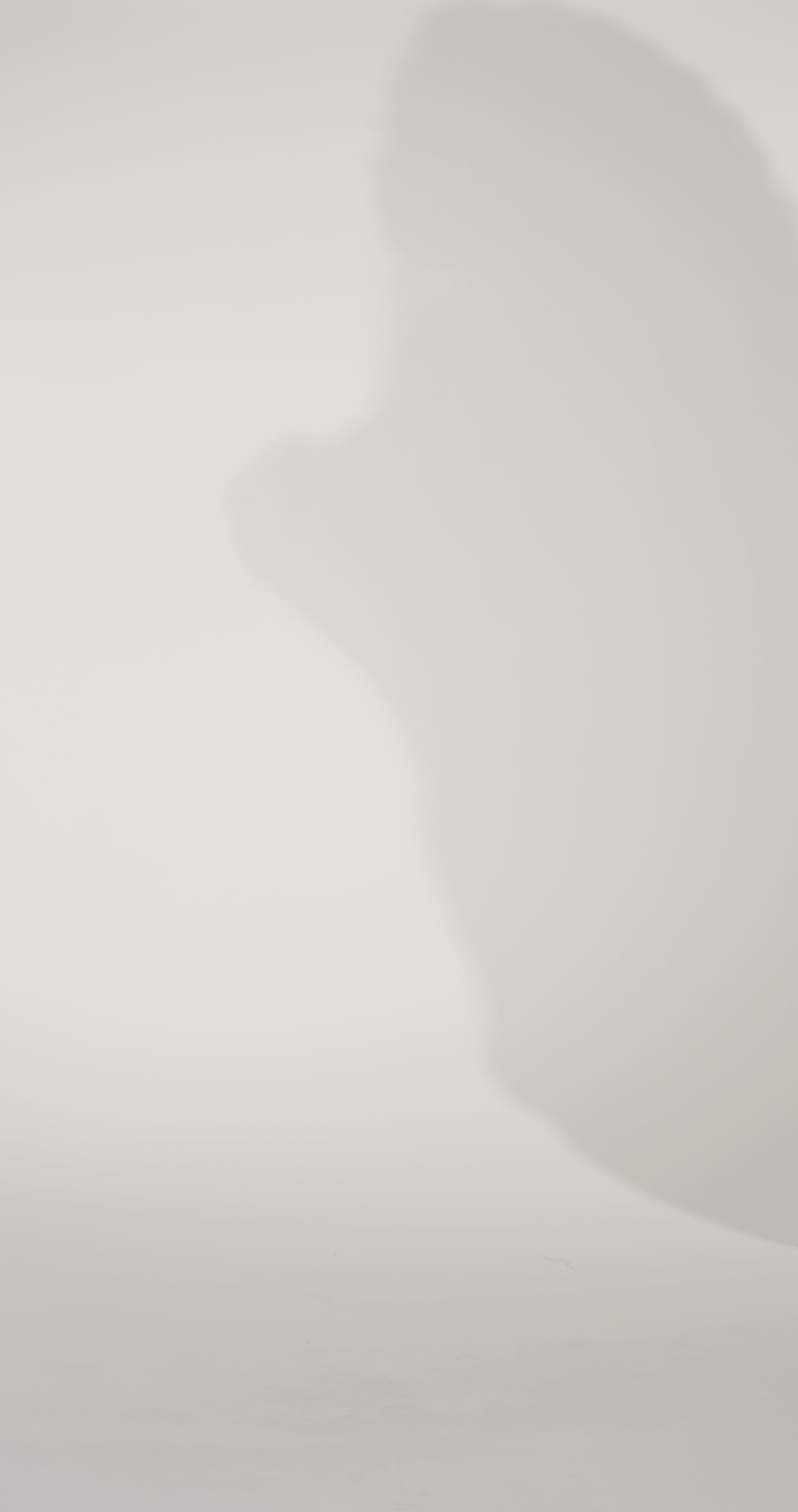 Woman models a strapless pink brocade A-line dress with a slit, turning to show the back before walking off screen.