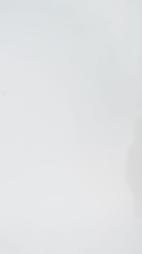 Woman models a black sequin A-line dress with a V-neckline and flowing cape sleeves, turning to show the back before walking off screen.