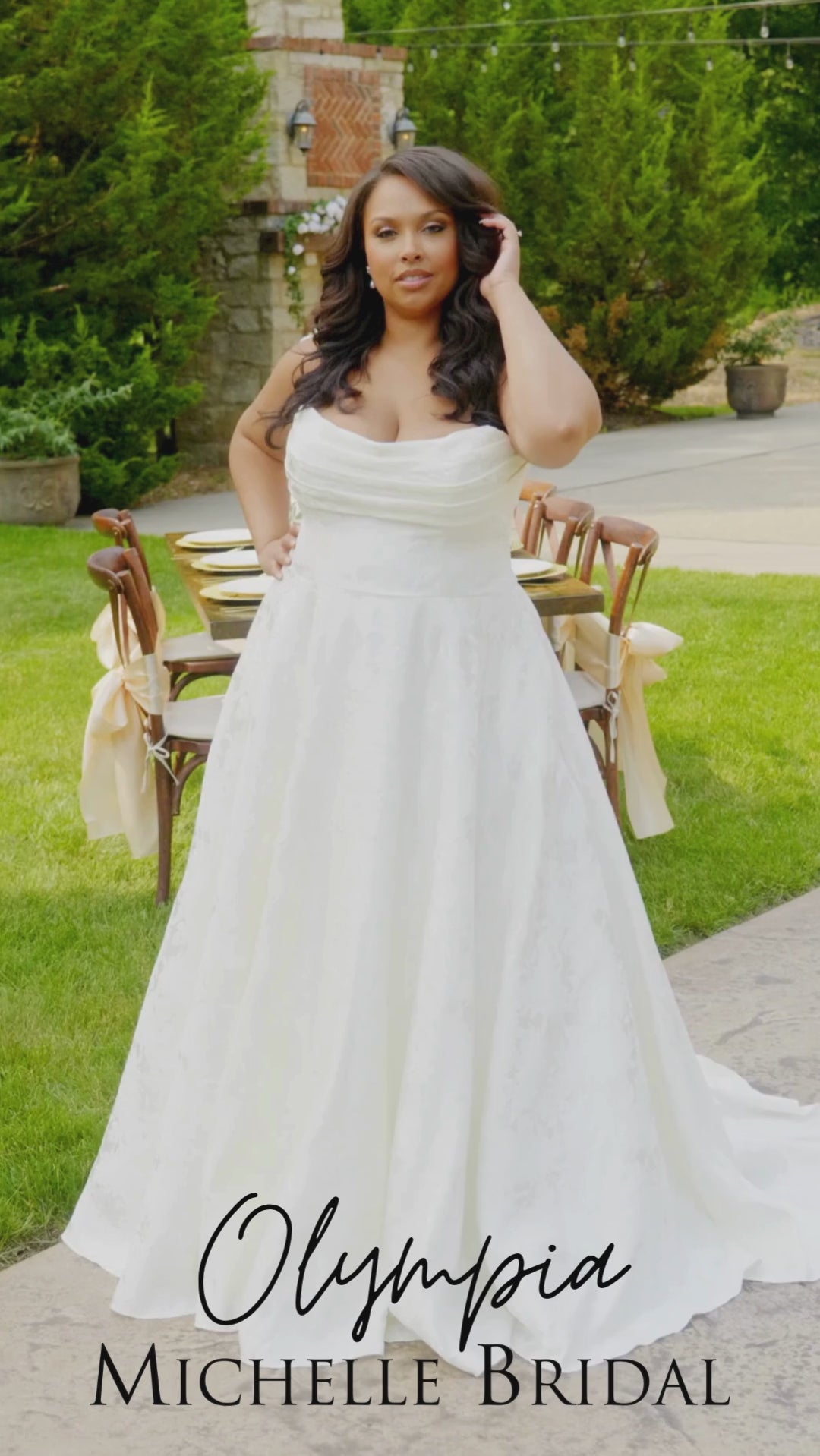 Video of a plus-size bride modeling the MB2601 wedding gown by Michelle Bridal, showcasing the structured bodice, flattering silhouette, and flowing skirt designed for curvy brides.