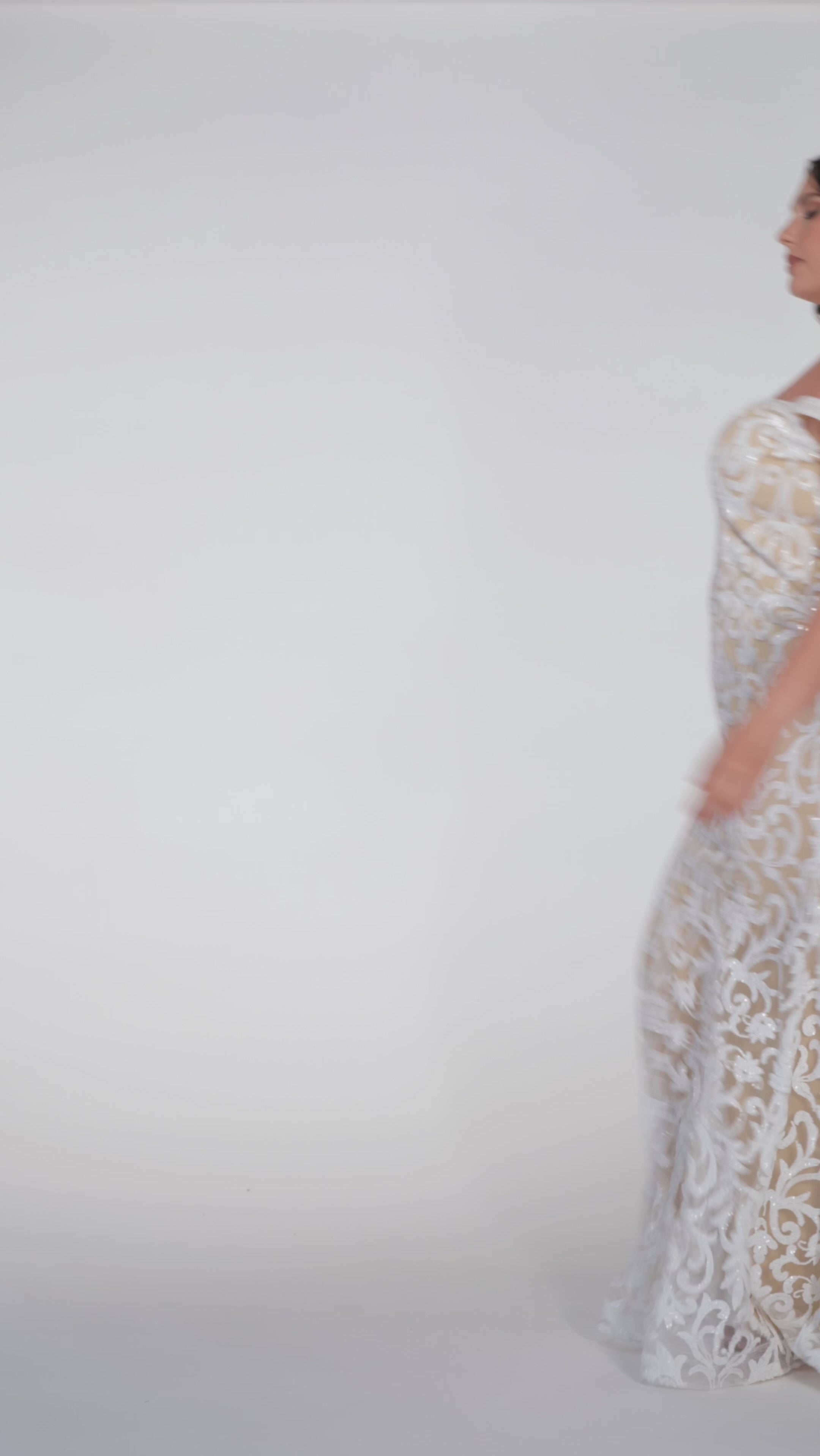 Plus-size woman wearing an off-the-shoulder nude and ivory sequin embroidered formal gown with sweetheart neckline, off-the-shoulder straps and fitted silhouette. CE2611 available from Sydney's Closet